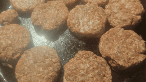 Close-up of cooked beef sausage patties on a skillet.