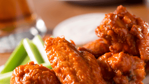 Delicious spicy chicken wings served with celery sticks for a WingTober event. Perfect for fall fest.